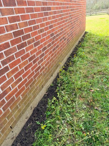 Termite Trenching Treatment Around Foundation Fresh trench dug along a home's foundation for a professional liquid termite treatment.